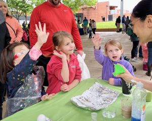 Three little children engaging in an activity with their hands in the air